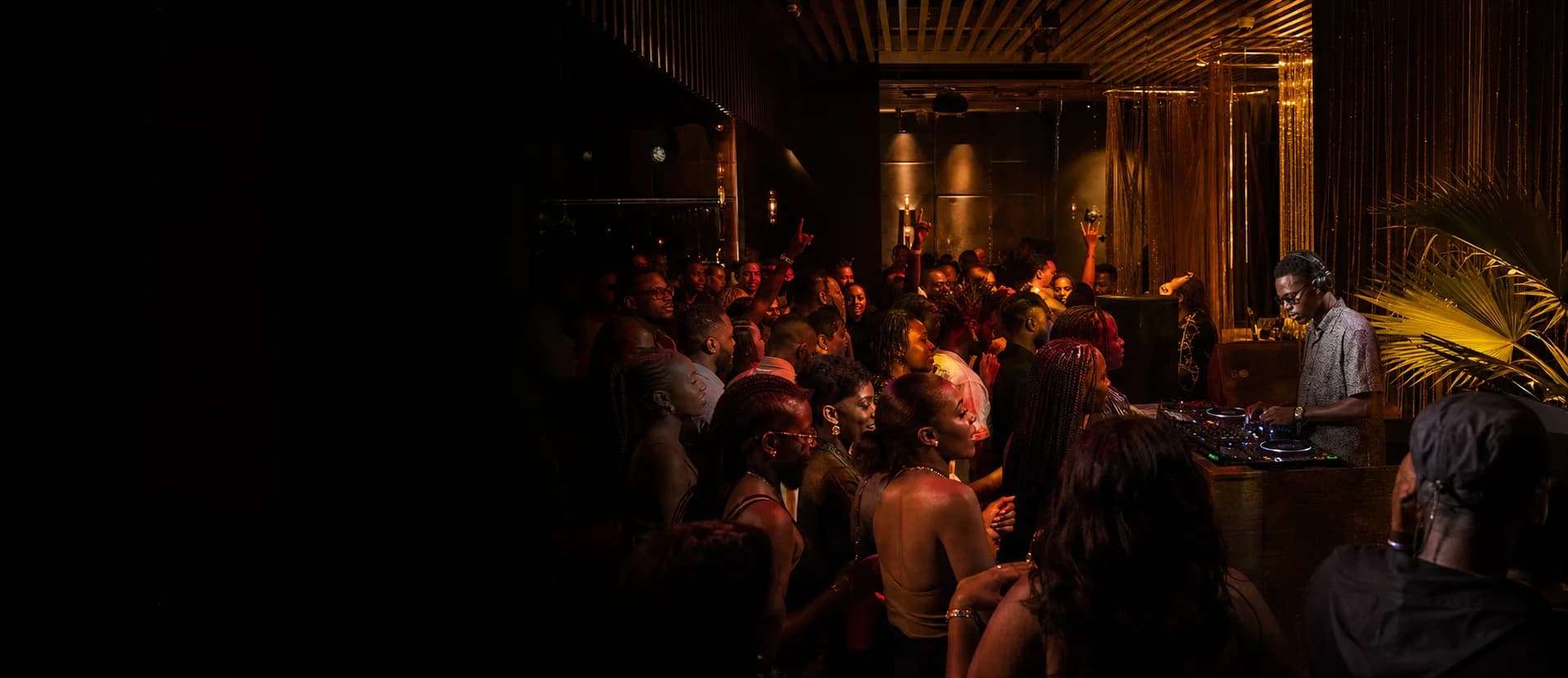 A DJ performing for a lively crowd in a contemporary African nightclub